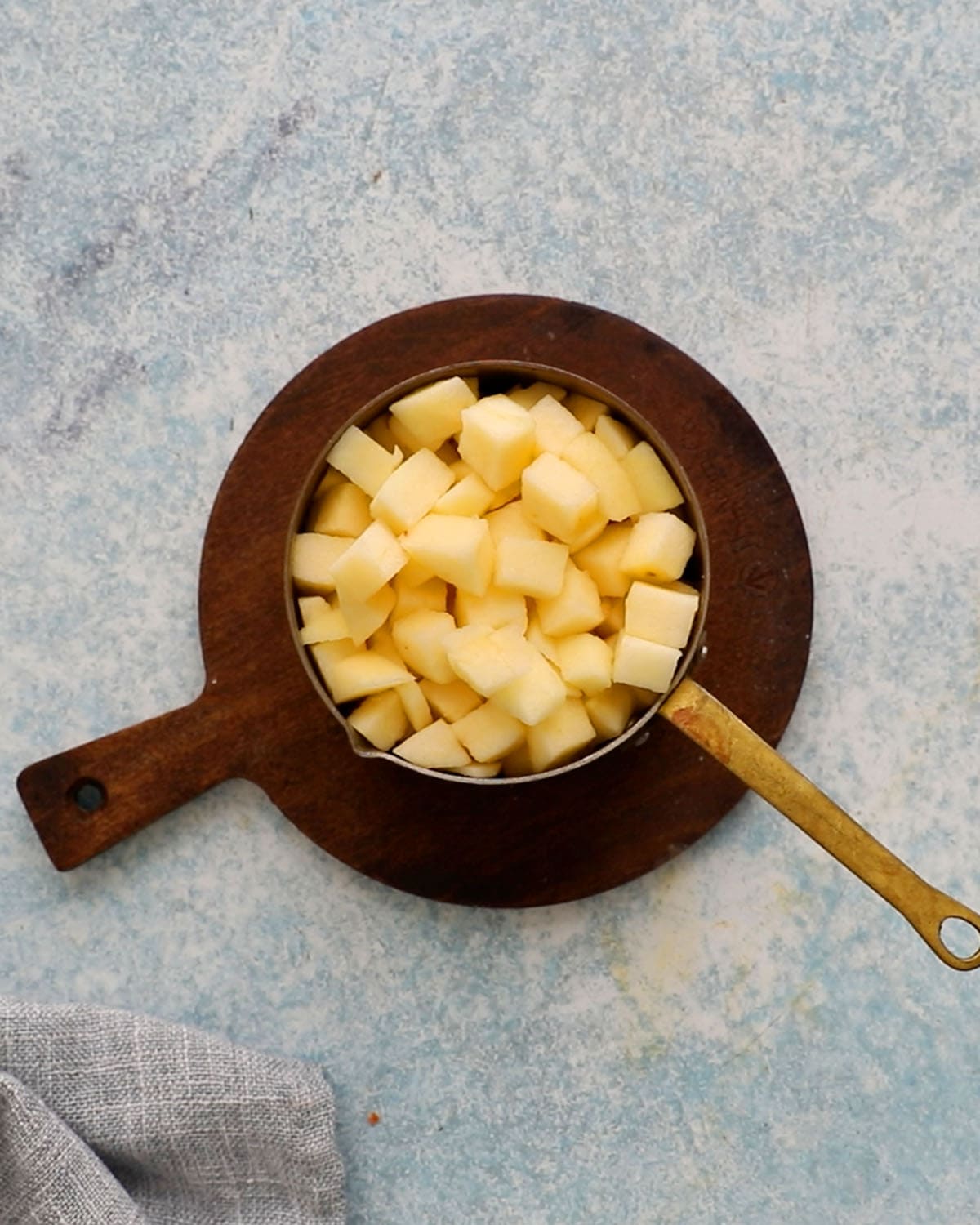 one measuring cup filed with diced apple cubes.