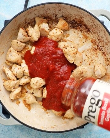 chicken alla vodka cooking in a white pan.