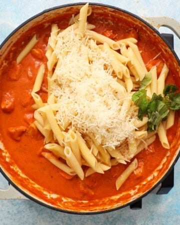 chicken vodka pasta cooking in a white pan.