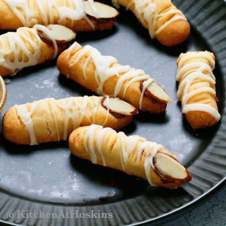 Halloween mummy cookies on a black plate.