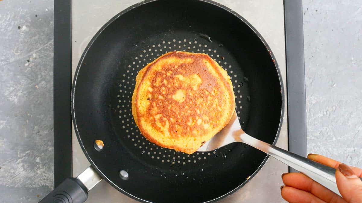 removing a cooked pancake from a skillet