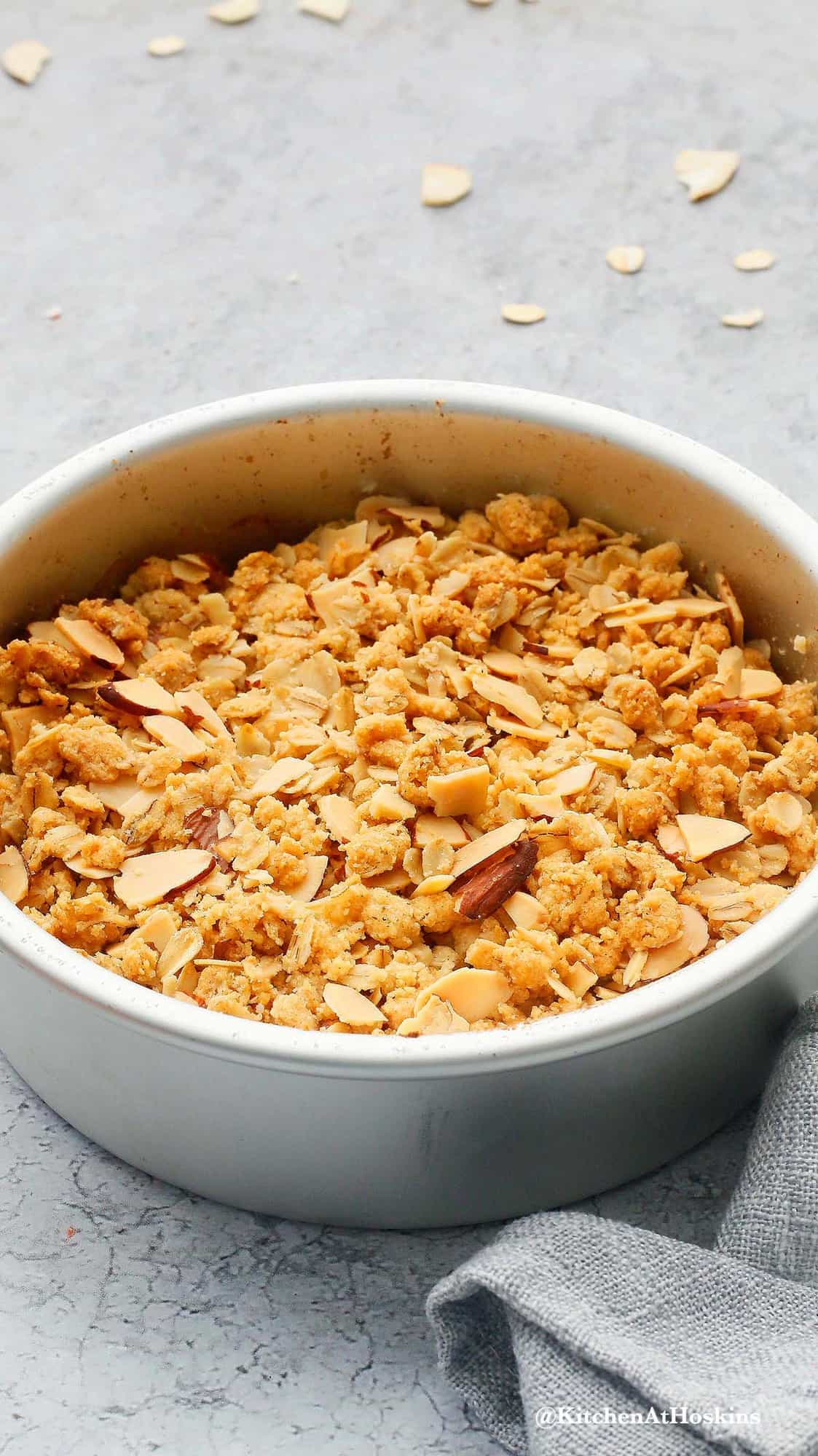 an aluminium round cake tin with baked apple crisp.