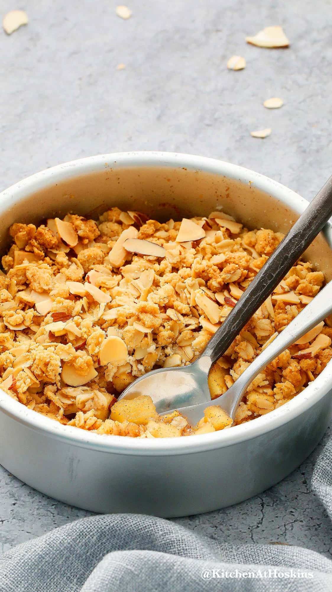 baking pan with apple crisp along with spoons