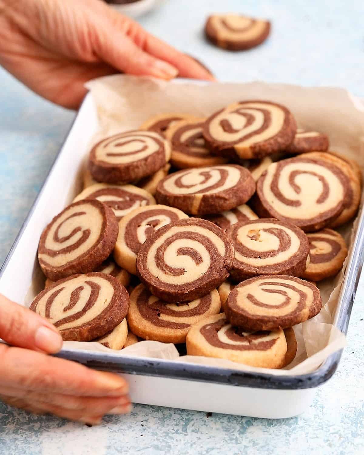 chocolate pinwheel cookies in a white tray.