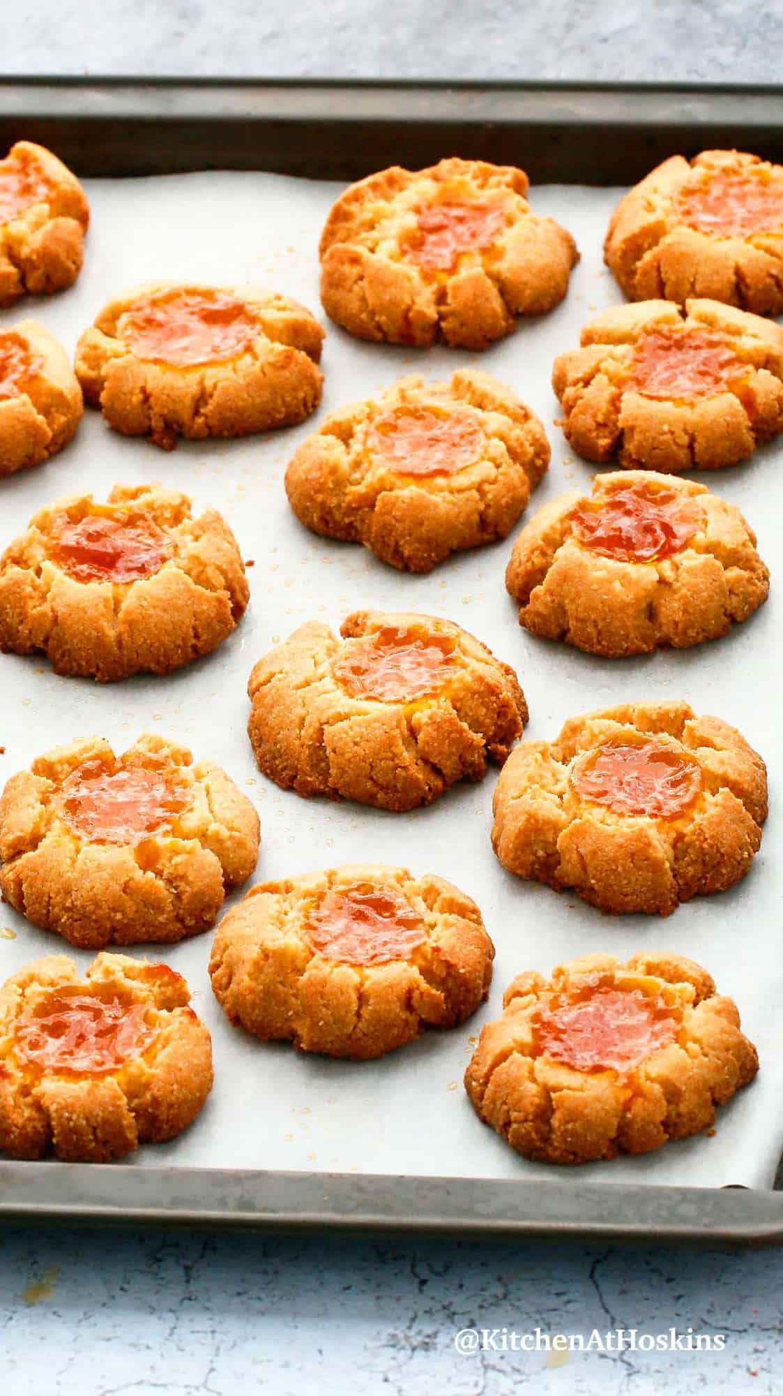 apricot thumbprint cookies on a baking tray.