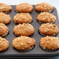 12 mini banana muffins in a metal muffin pan.