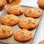 6 baked persimmon muffins in a metal muffin pan.