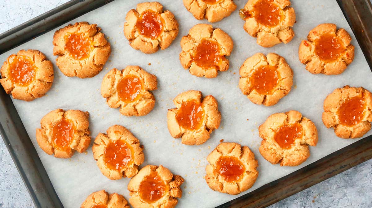 baked almond flour thumbprint cookie dough in a baking sheet.