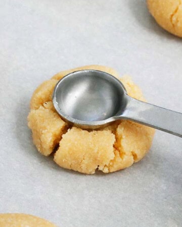 a small measuring spoon placed in the middle of a cookie dough.