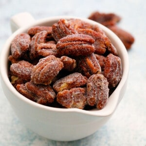 a white bowl filled with candied pecans.