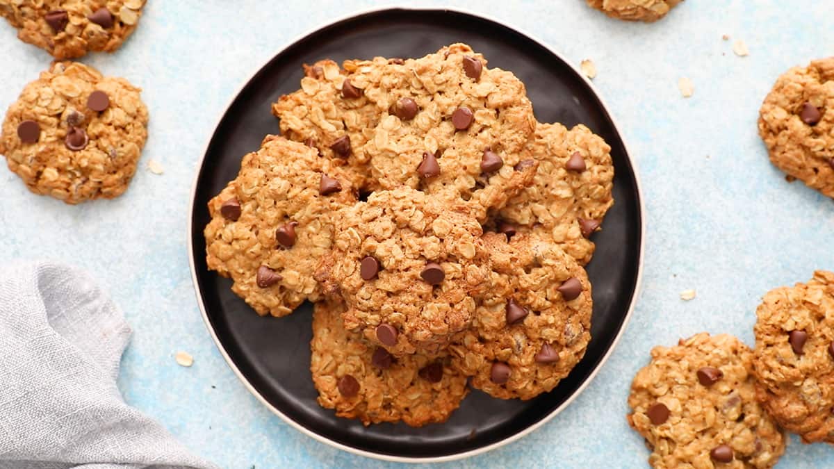 6 oatmeal chocolate chip cookies placed on a round black plate.
