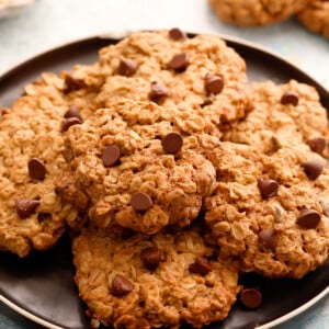 6 oatmeal chocolate chip cookies placed on a round black plate.