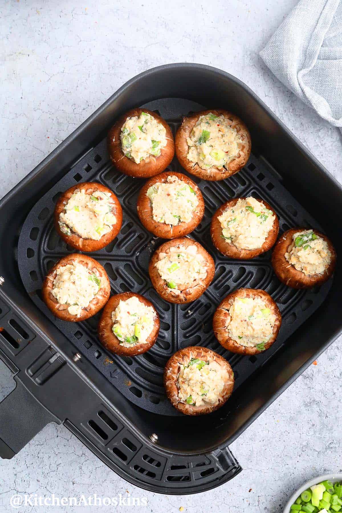 air fryer basket with mushroom caps filled with Italian cream cheese mixture.