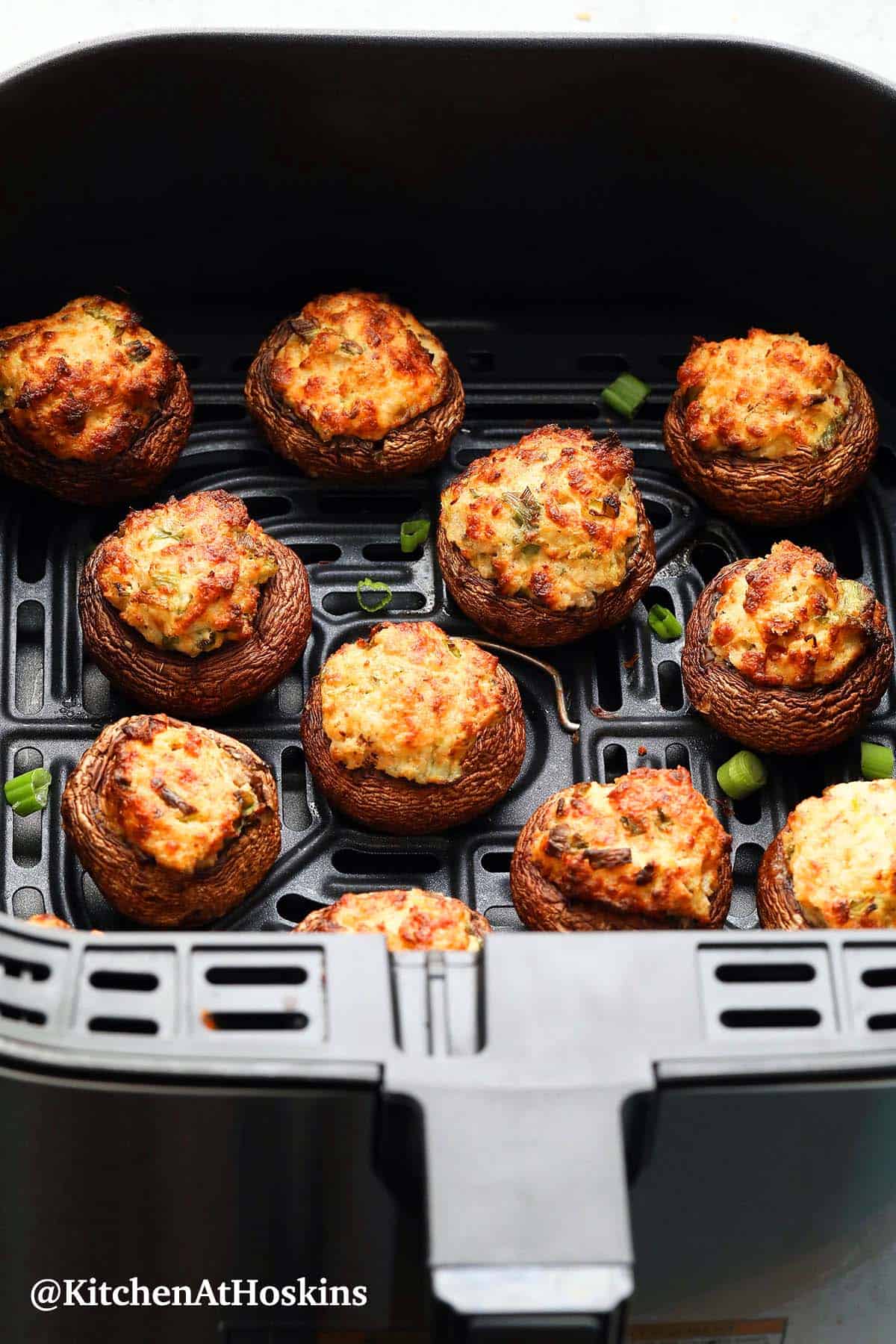 air fryer basket with stuffed mushrooms.