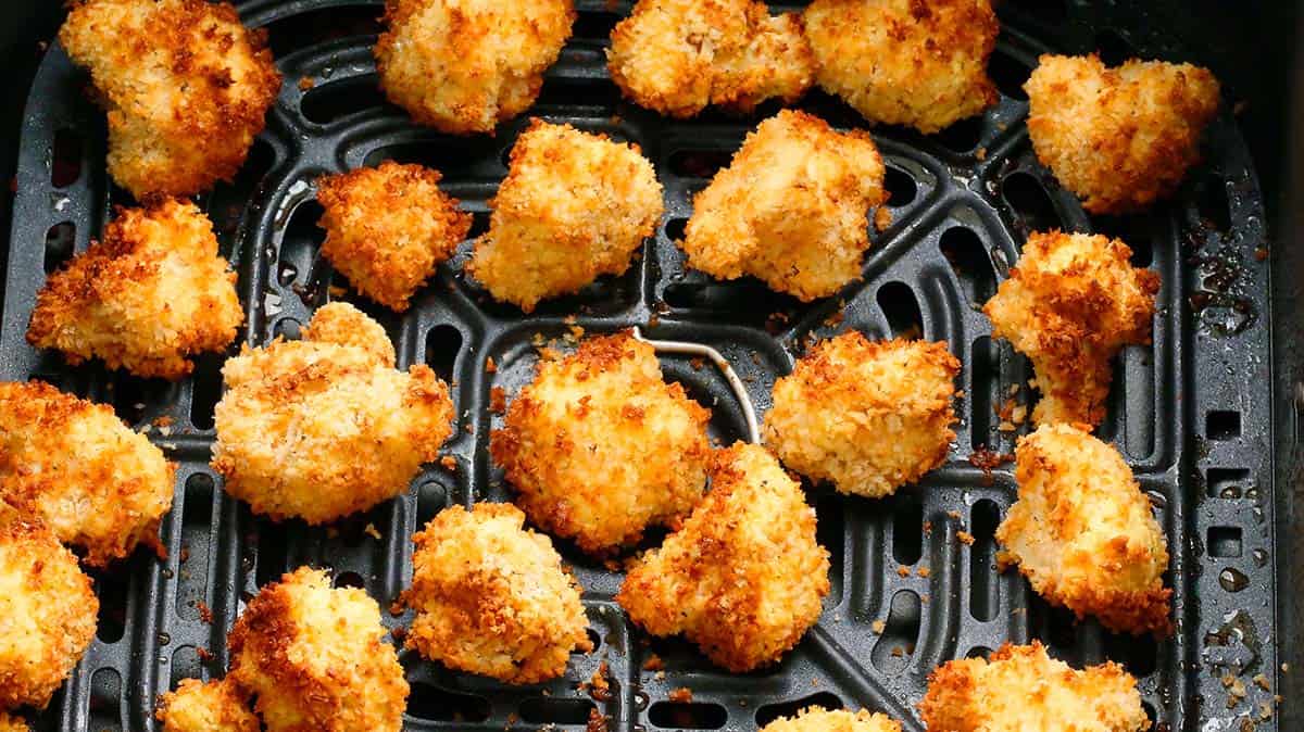 air fried crispy cauliflower in an air fryer basket.