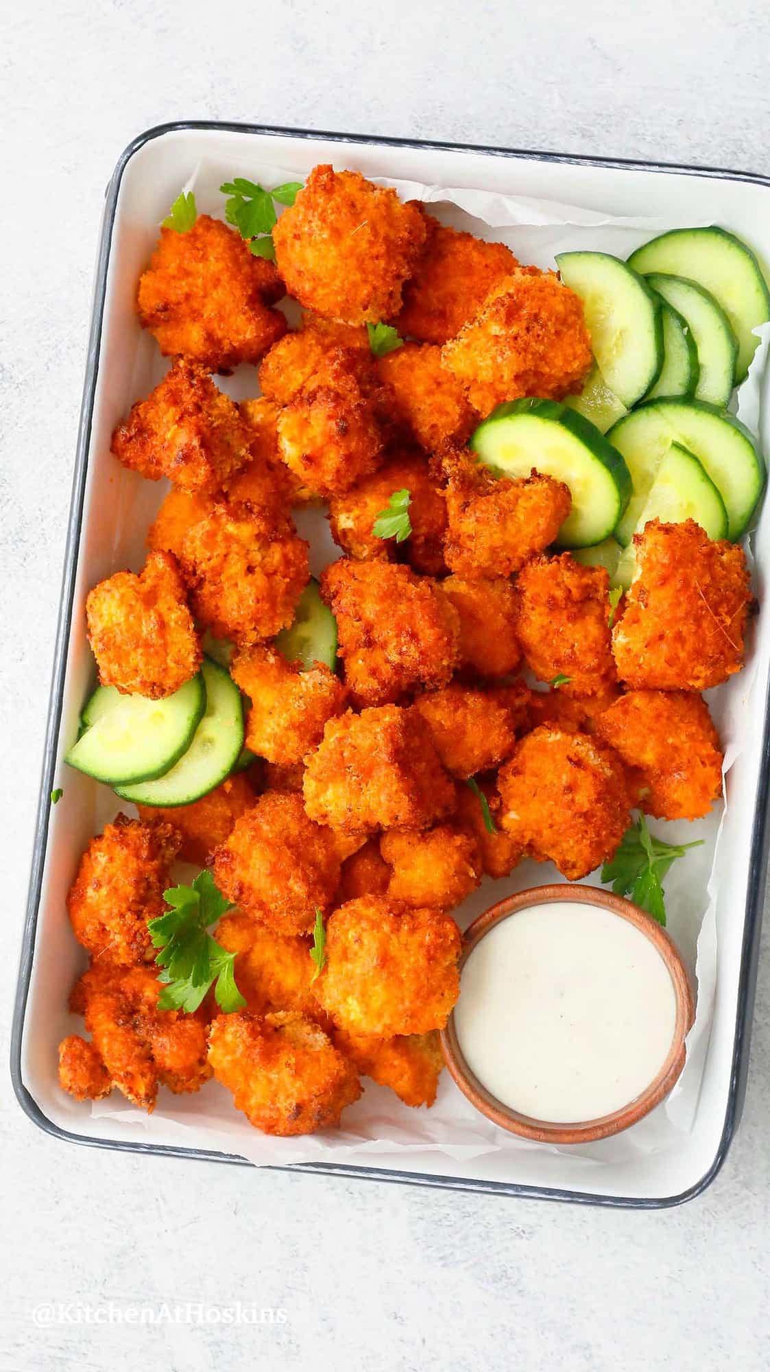 spicy air fried cauliflower wings, cucumber slices with dipping sauce.