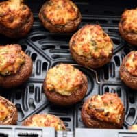 cream cheese stuffed mushrooms in air fryer basket.