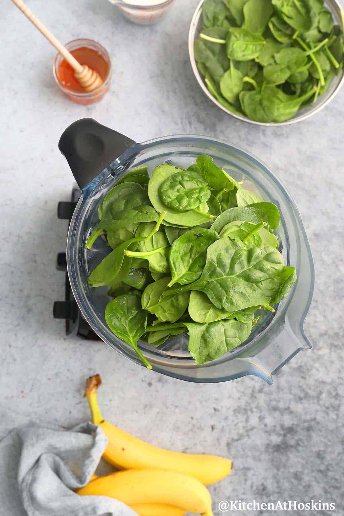 a blender filled with fresh baby spinach.