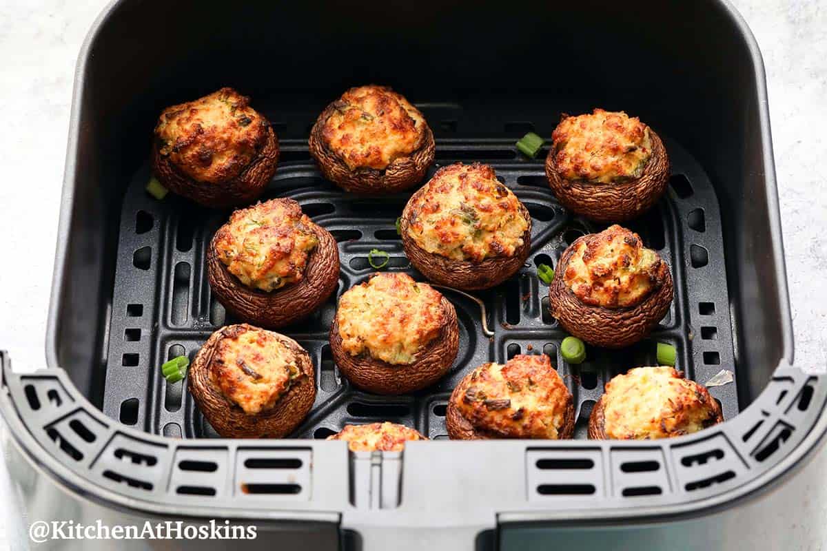 air fryer basket with stuffed mushrooms.