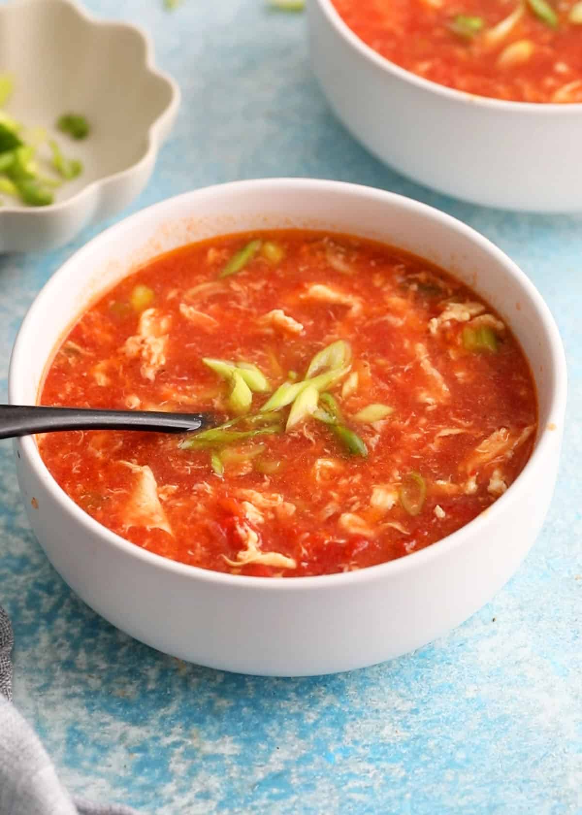 tomato egg soup in two white bowls.