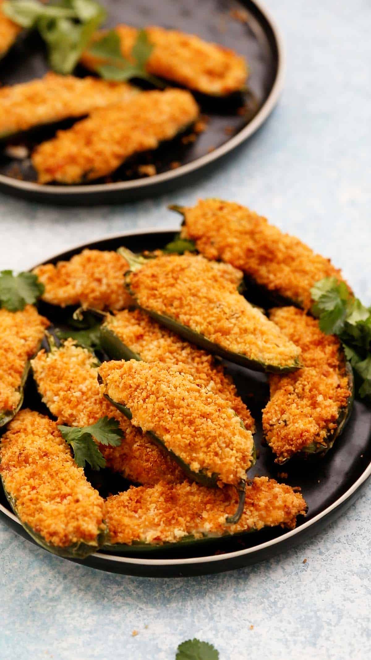 two round black plates filled with jalapeno poppers.
