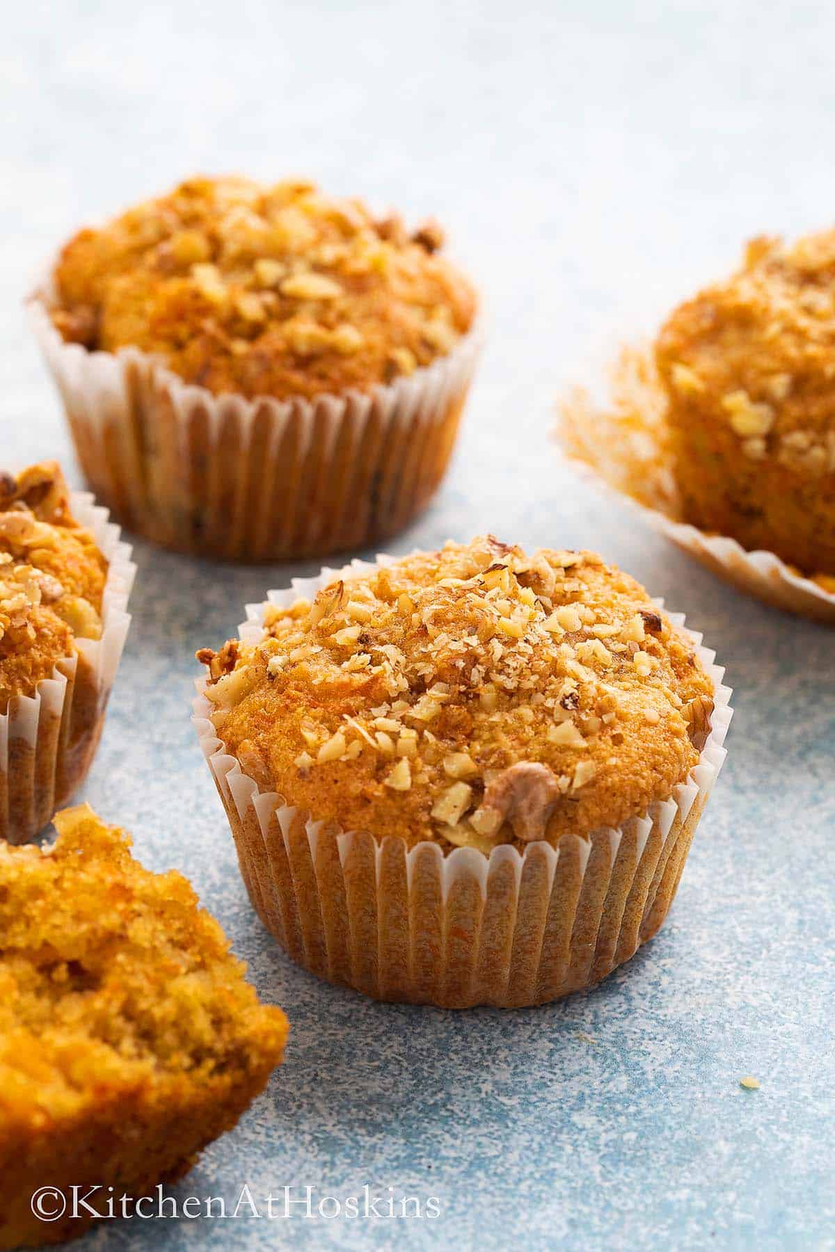 4 carrot muffins on a blue board.