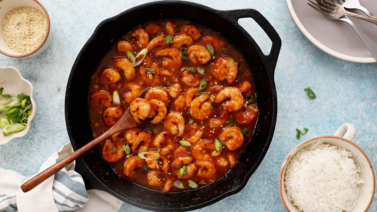 stir fried firecracker shrimp in a black skillet.