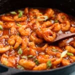 stir fried firecracker shrimp in a black skillet.