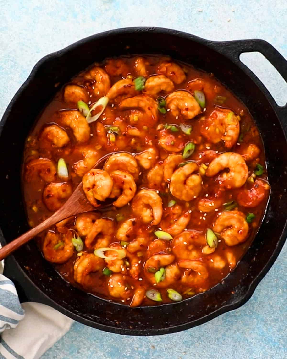 stir fried firecracker shrimp in a black skillet.