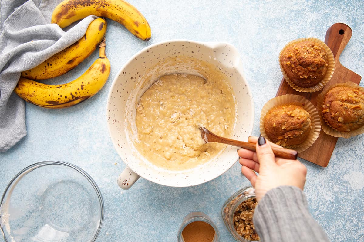 mixing muffin batter with mashed banana.