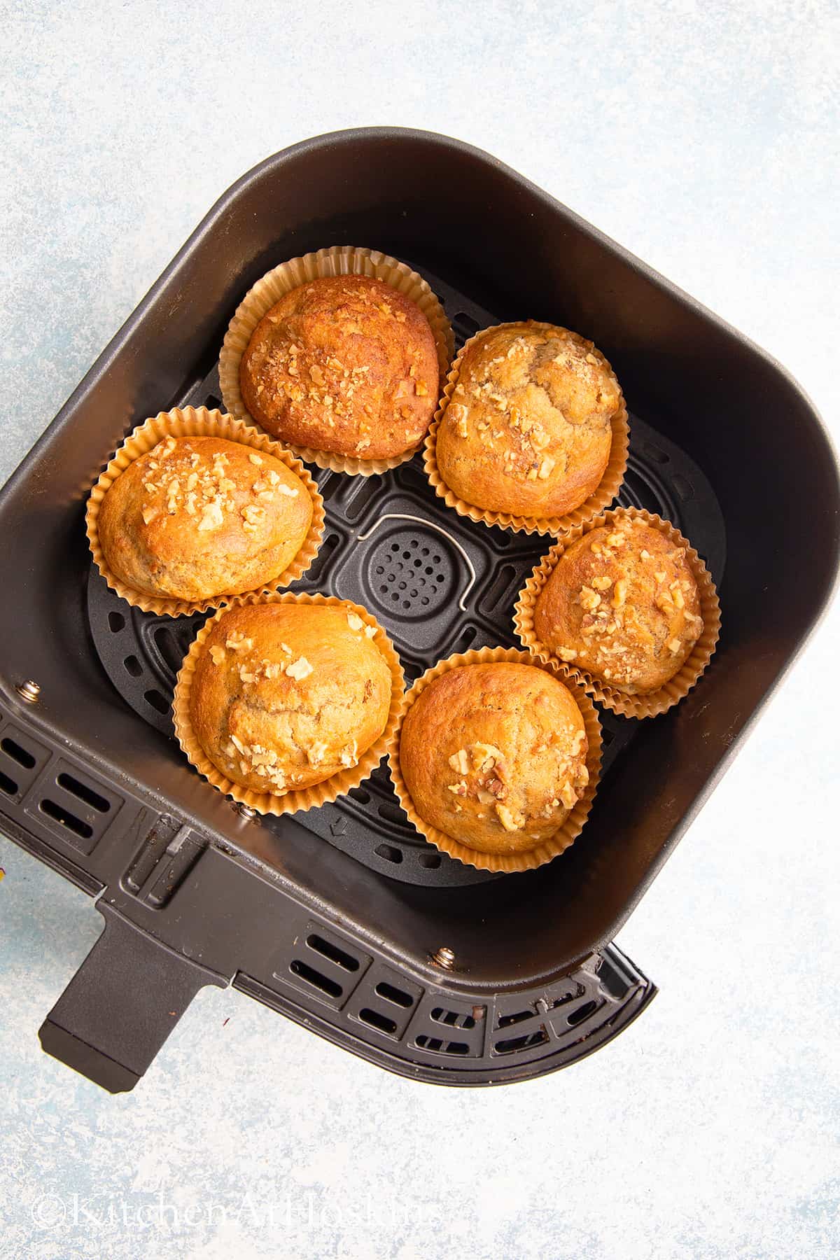 banana bread muffins in air fryer basket. 