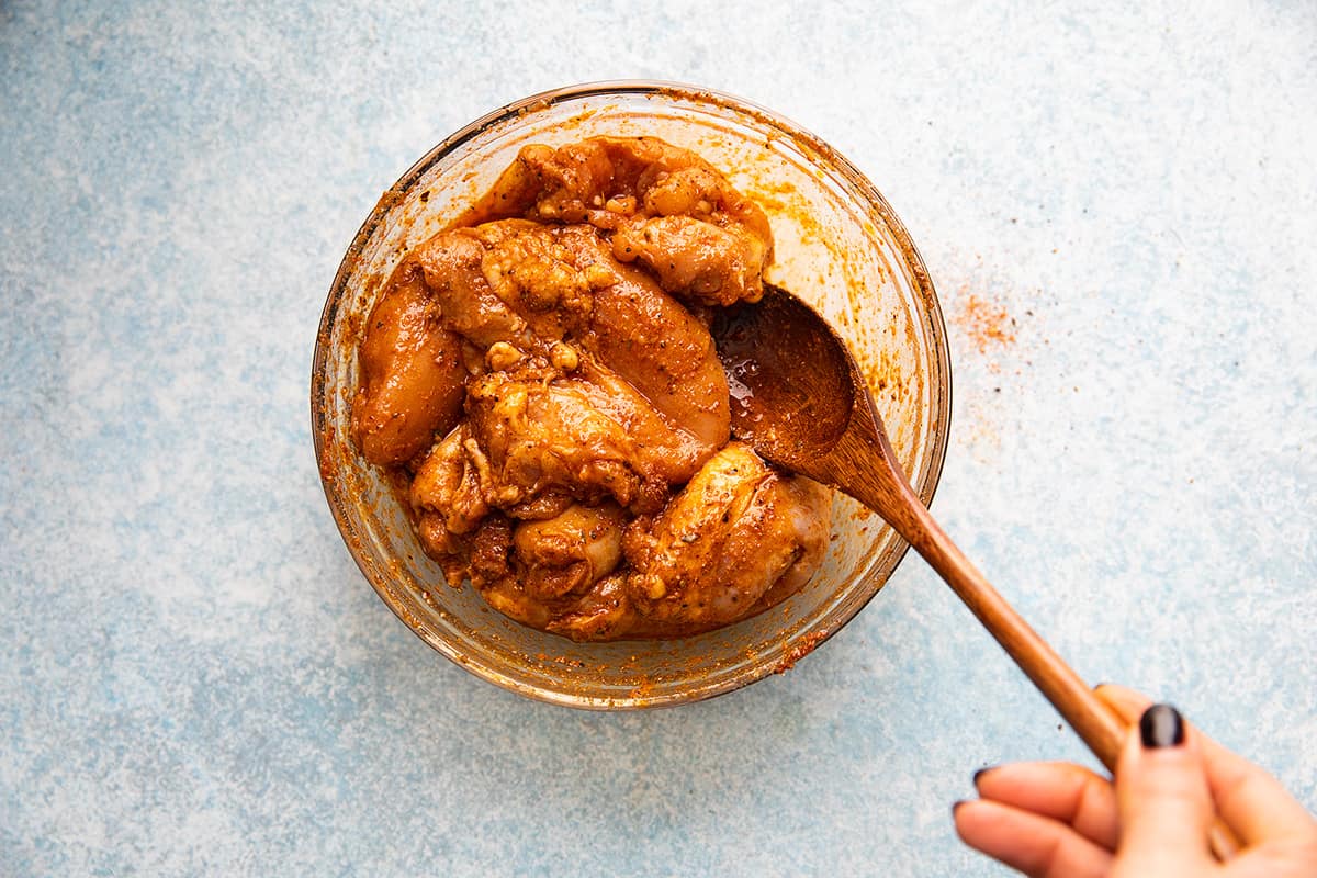 chicken thighs mixed with taco seasoning in a bowl. 