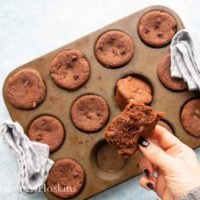 a hand holding a cut chocolate muffin.