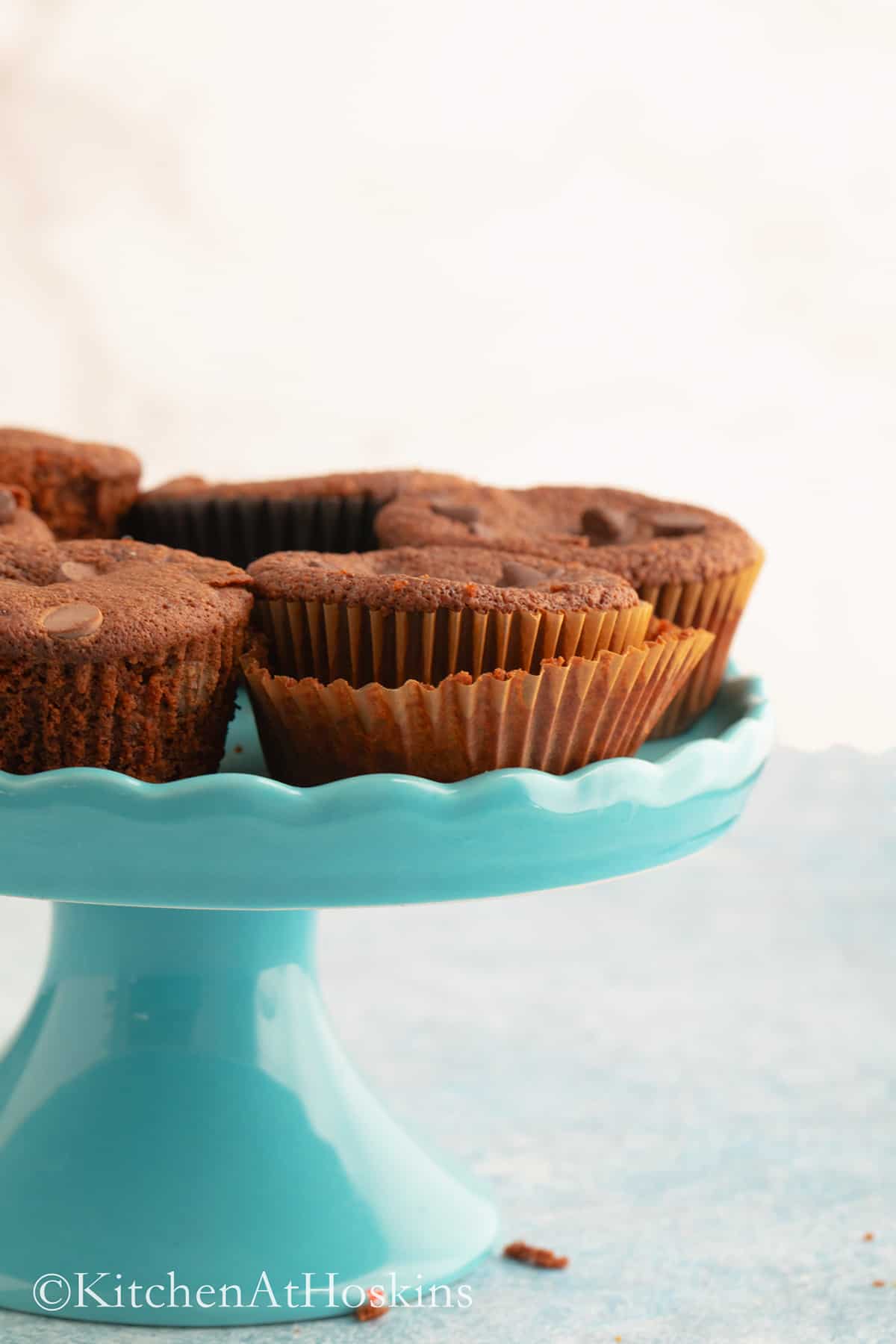 almond flour chocolate muffins on a blue cake stand. 