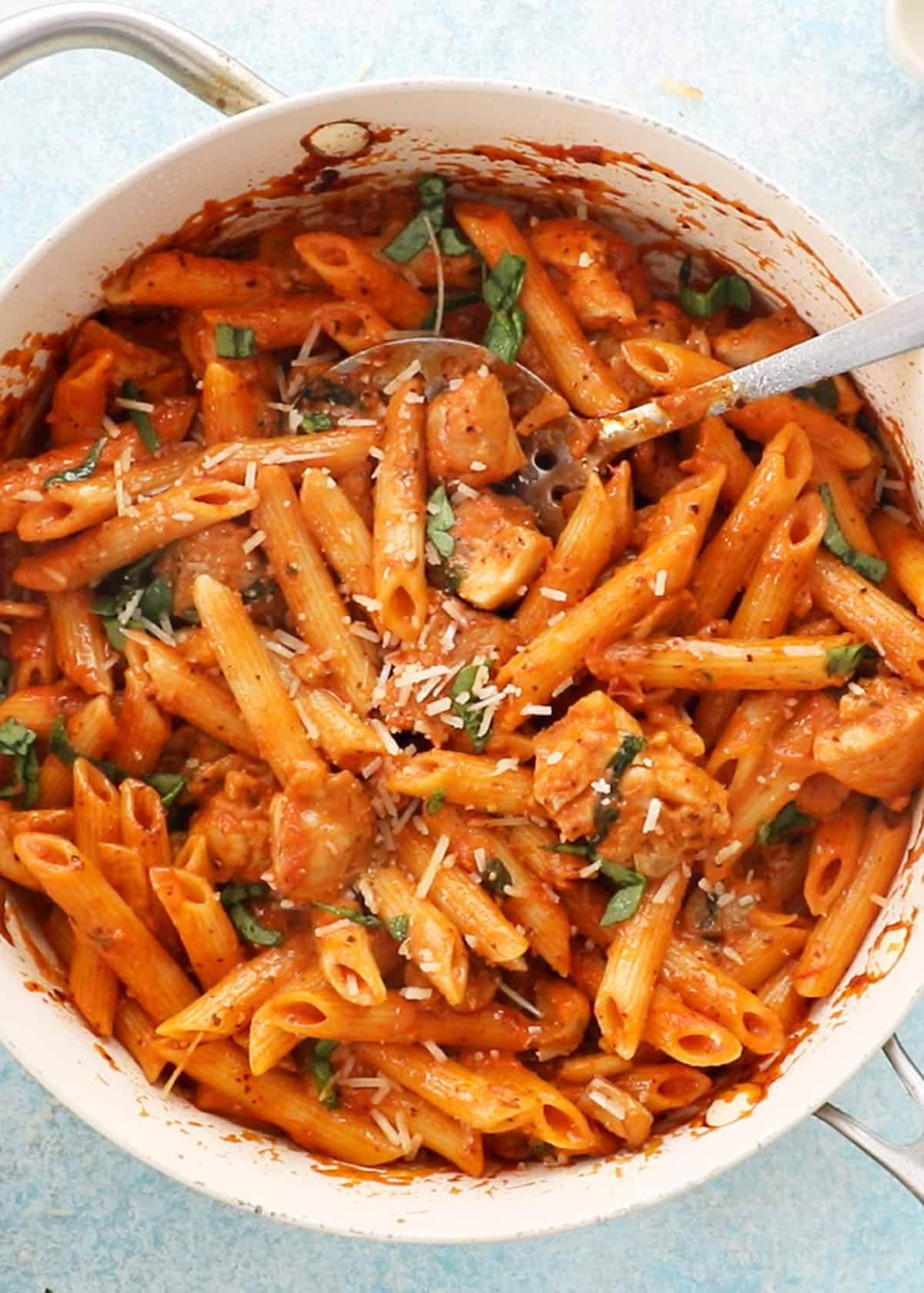 red pasta in a white pan.