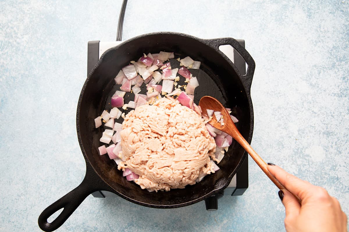 Saute ground chicken with onion in a skillet. 
