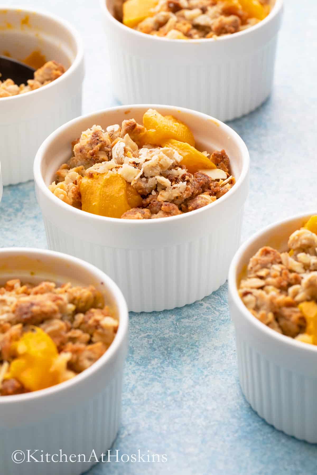 white ramekins with baked mango crumble. 