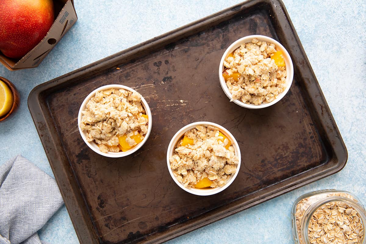 mango crumble with oat topping in ramekins. 