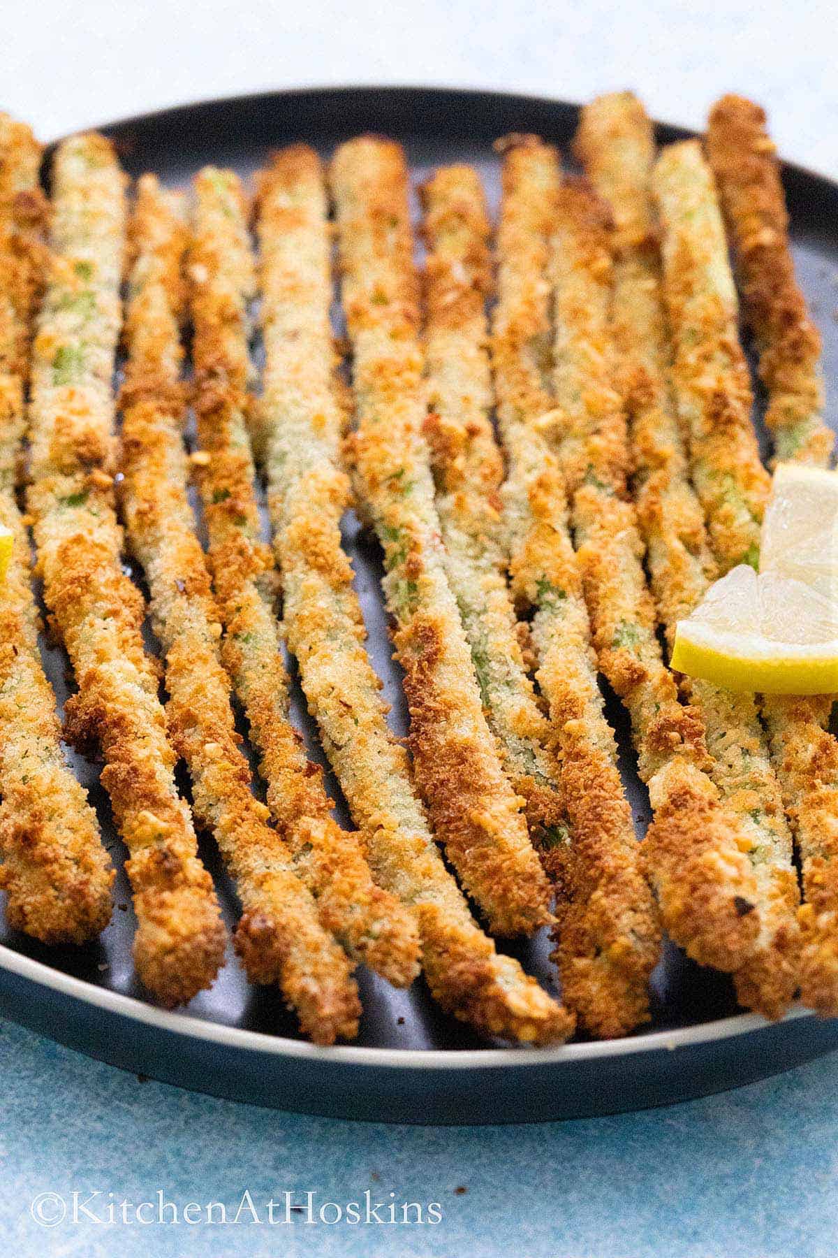 air fried asparagus on a black plate.