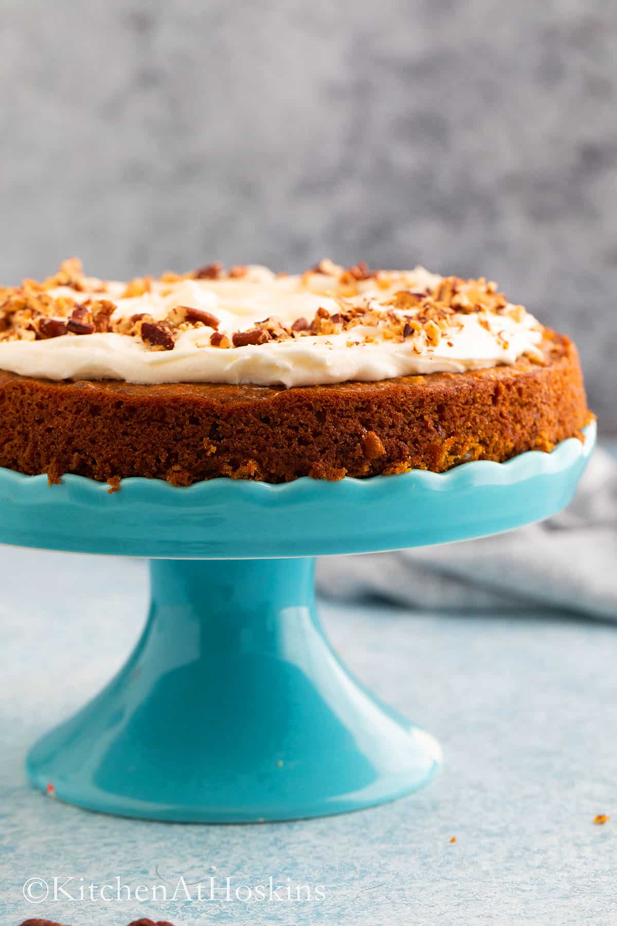frosted single layer eggless carrot cake on a stand. 