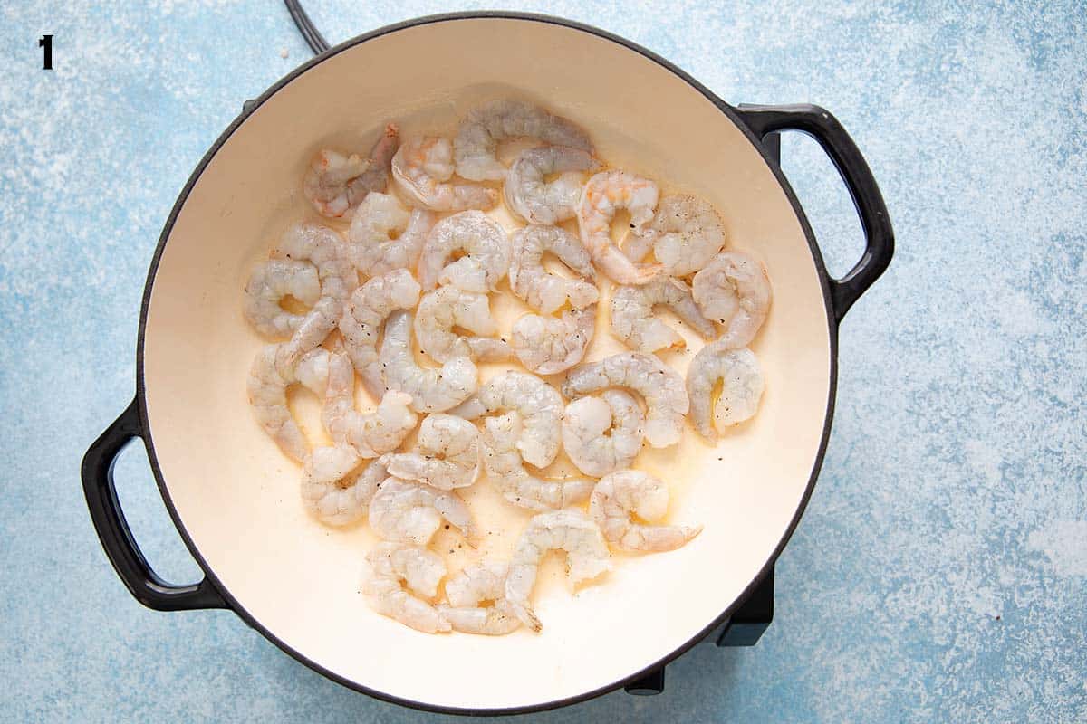 shrimp cooking in a white skillet.