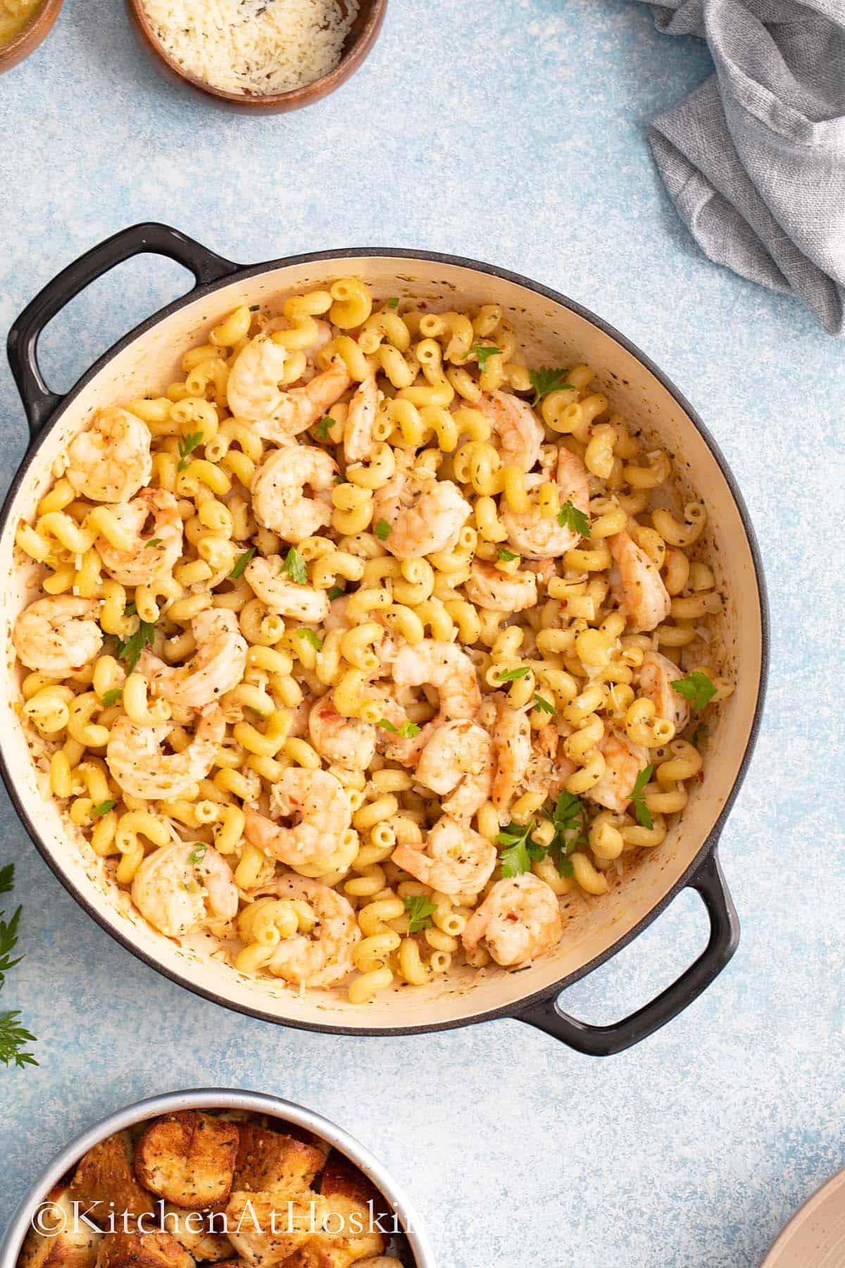 garlic butter shrimp and pasta in a black handled pan.