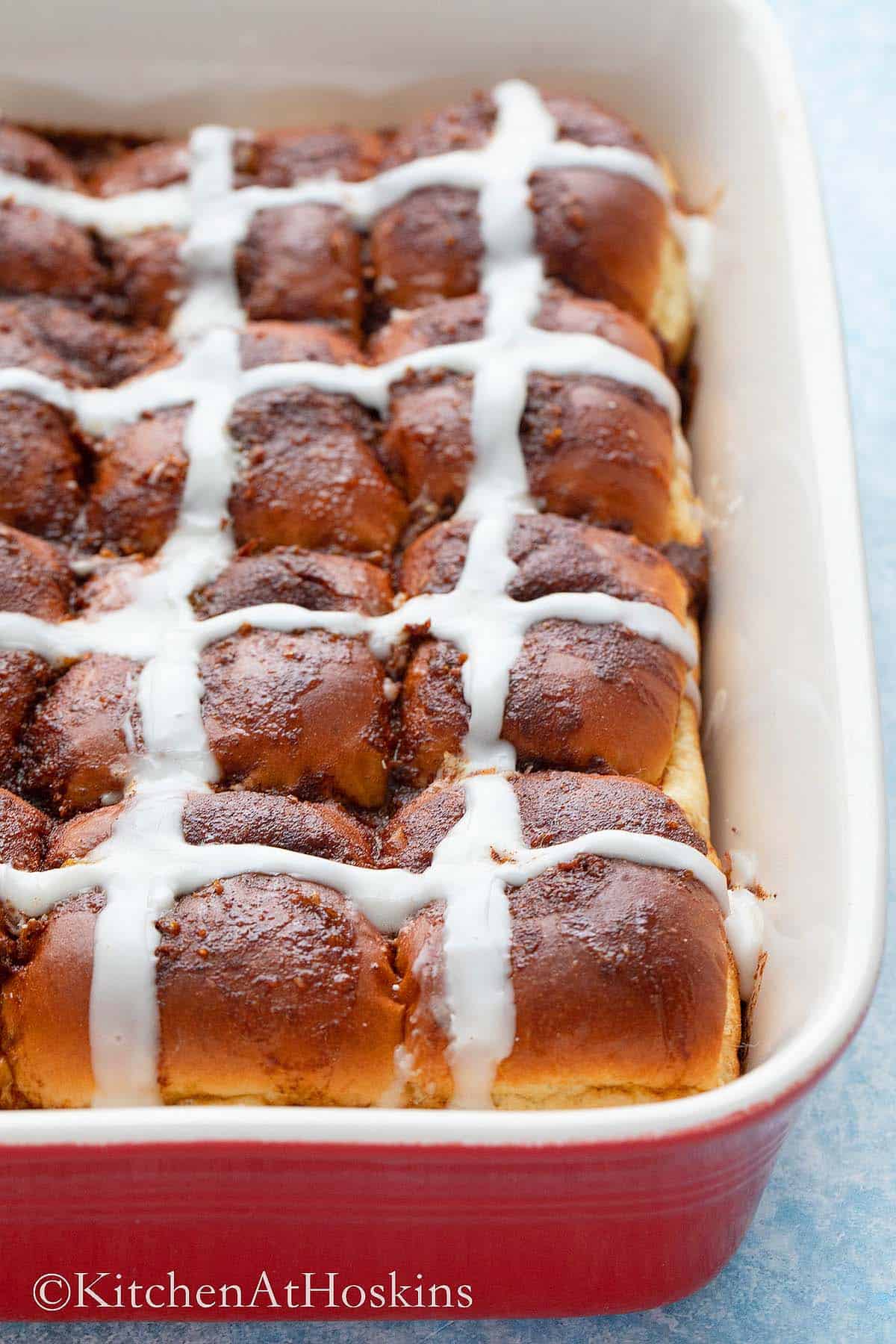 one red baking dish with hot cross buns.
