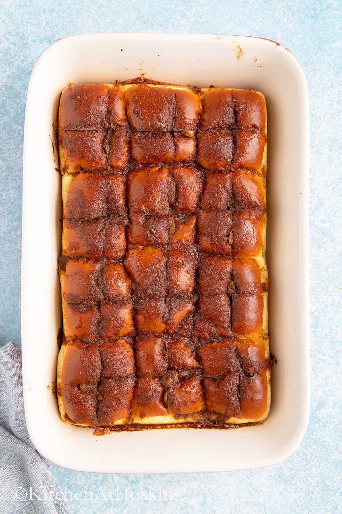 baked hot cross buns in a red rectangle baking dish.