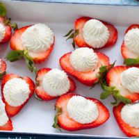 STRAWBERRY HALFS TOPPED WITH WHIPPED CREAM.