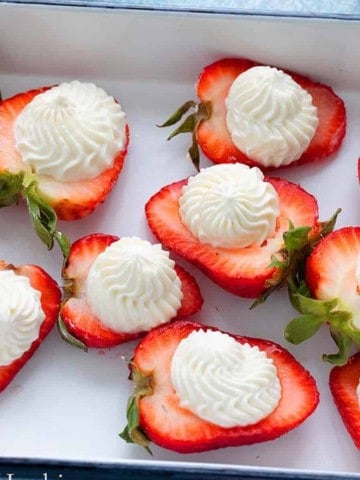 STRAWBERRY HALFS TOPPED WITH WHIPPED CREAM.