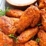 air fryer buffalo wings on a tray with dipping sauce.