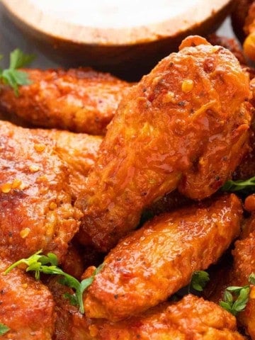 air fryer buffalo wings on a tray with dipping sauce.