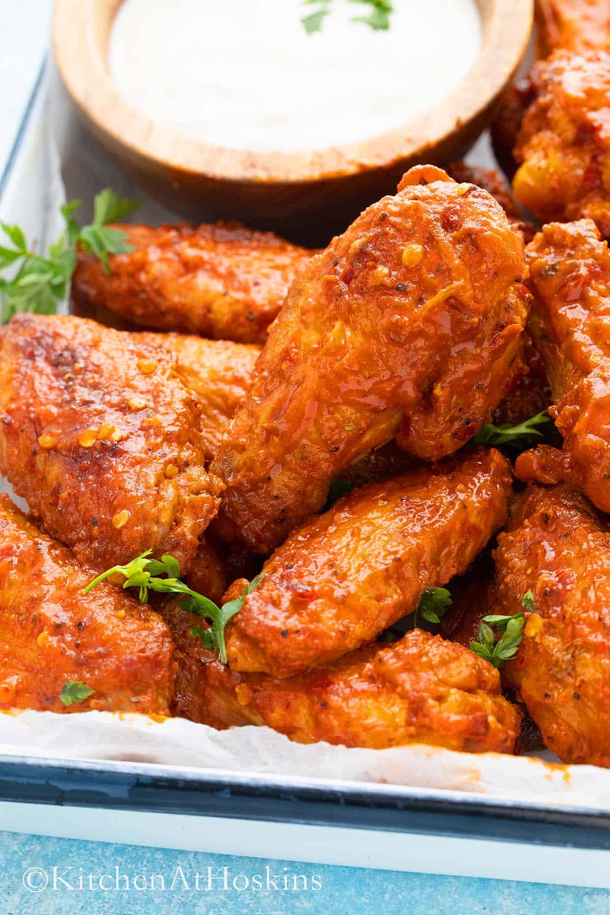spicy buffalo wings on a tray with ranch in a small bowl.