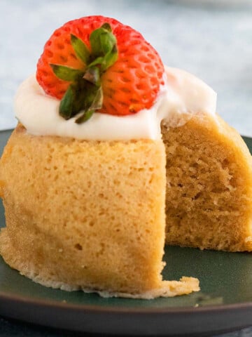 almond flour cake topped with cream and strawberrry.